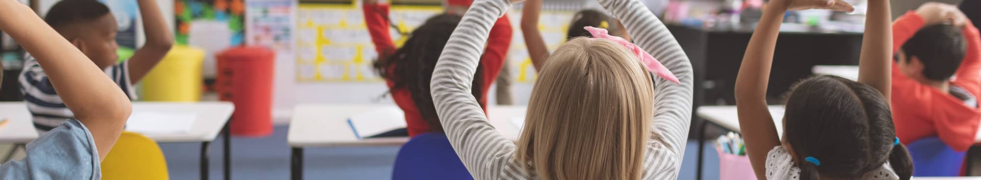 Students Stretching Arms to the Sky in a Classroom