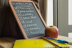 Chalkboard with school supply list on a desk